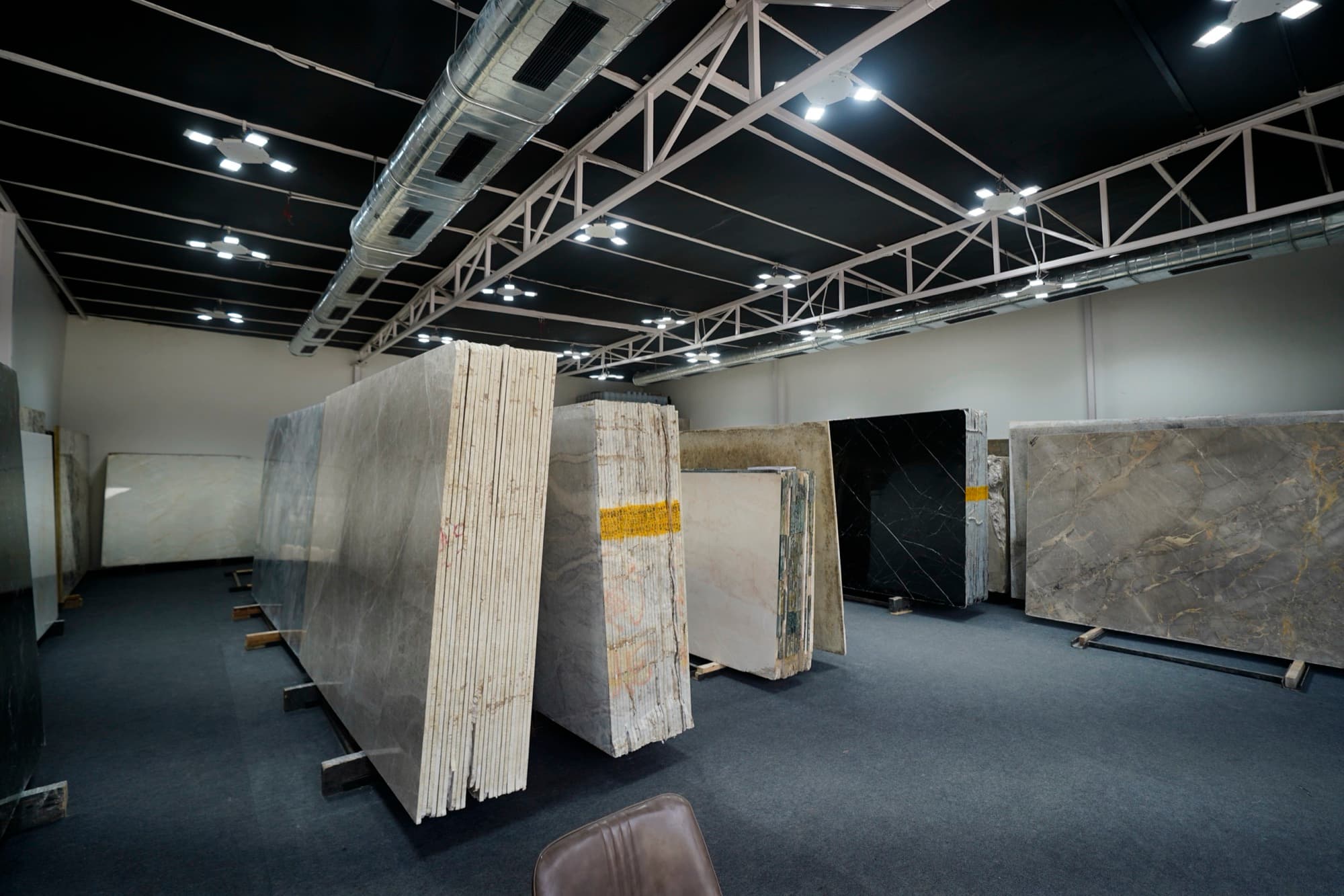 Slabs standing under the lights inside Flora Marble's Mumbai gallery